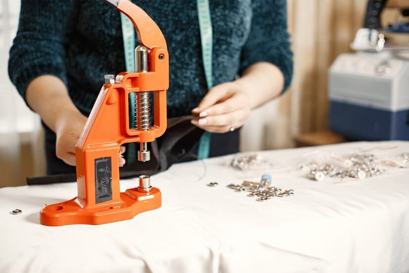 1 About Us orange press clothes buttons fabric woman with sewing tools 1157 46476